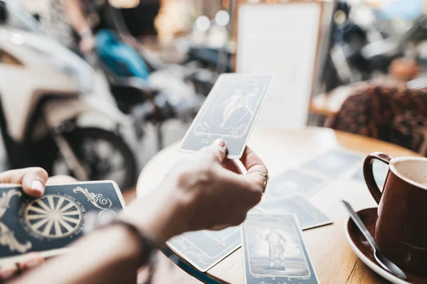 Femme lit des cartes de tarot sur la table dans un café — Photo