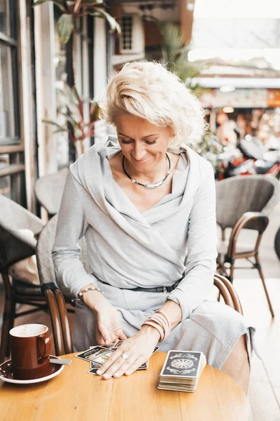 Mujer está leyendo cartas del Tarot en la mesa en la cafetería — Foto de Stock