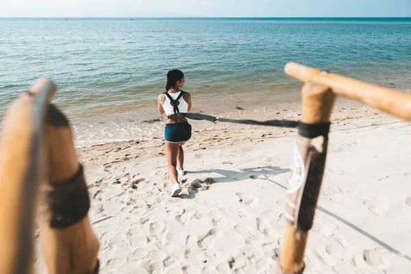 Donna accovacciata in Eco palestra sulla spiaggia — Foto Stock
