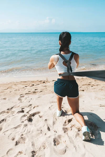 Woman squatting in Eco gym on the beach