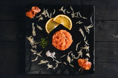 Somon ve chia tohumlu tart. Siyah taş levhada servis edilen taze salata. Üst görünüm