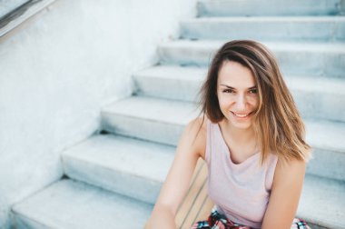 Uzun pano sürüşünden sonra merdivenlerde dinlenen şapkalı çekici kadın..