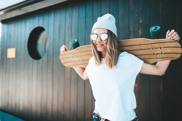 Ελκυστική Γυναίκα Γυαλιά Ηλίου Και Καπέλο Στέκεται Στον Τοίχο Longboard — Φωτογραφία Αρχείου
