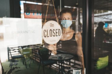 Tıbbi maskeli kadın karantina nedeniyle restoranı kapattı.