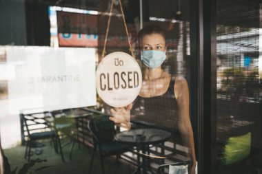 Tıbbi maskeli kadın karantina nedeniyle restoranı kapattı.