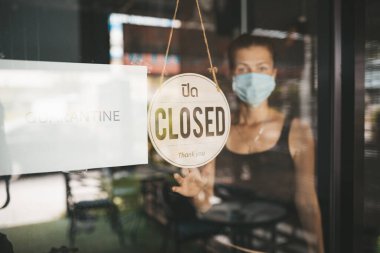 Tıbbi maskeli kadın karantina nedeniyle restoranı kapattı.