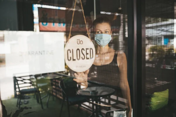 Tıbbi maskeli kadın karantina nedeniyle restoranı kapattı.