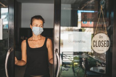 Tıbbi maskeli kadın karantina nedeniyle restoranı kapattı.