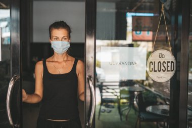 Tıbbi maskeli kadın karantina nedeniyle restoranı kapattı.