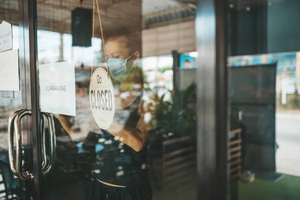 Tıbbi maskeli kadın karantina nedeniyle restoranı kapattı.