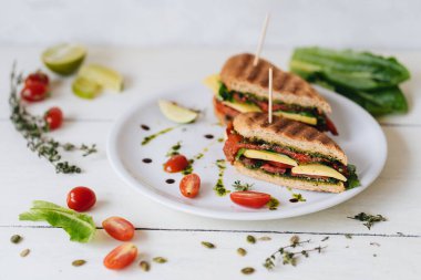 Kırmızı biberli panini ve beyaz tabakta pesto.