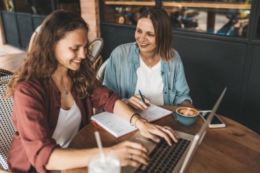 Kahve içerken iş projelerini tartışan iki kadın. Başlangıç, fikirler ve beyin fırtınası konsepti
