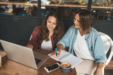 Kahve içerken iş projelerini tartışan iki kadın. Başlangıç, fikirler ve beyin fırtınası konsepti