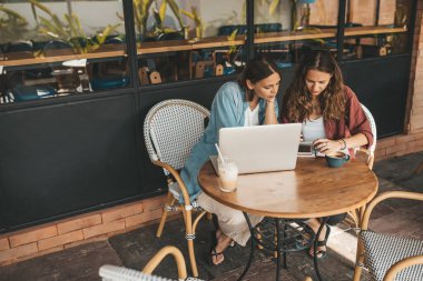 Kahve içerken iş projelerini tartışan iki kadın. Başlangıç, fikirler ve beyin fırtınası konsepti