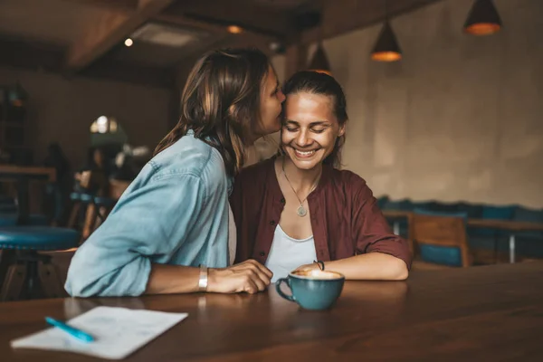 Gelukkige Jonge Vrouw Die Haar Vriendin Kust Zittend Een Café — Stockfoto