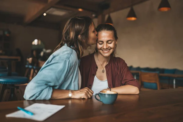 Gelukkige Jonge Vrouw Die Haar Vriendin Kust Zittend Een Café — Stockfoto