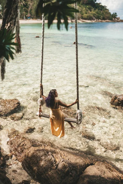 ブルネット女の子で黄色のドレスオンスイングでザビーチでタイ — ストック写真