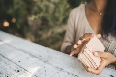 Tarot kartlarıyla kadın ellerini kapat. Kartlara odaklan. Bulanık arkaplan