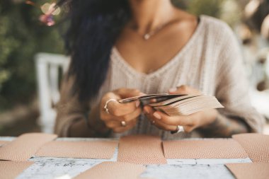 Tarot kartlarıyla kadın ellerini kapat. Kartlara odaklan. Bulanık arkaplan