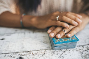 Tarot kartlarıyla kadın ellerini kapat. Kartlara odaklan. Bulanık arkaplan