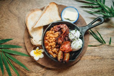 İki yumurtalı kahvaltı, sosis, pastırma ve fasulye. Üst görünüm