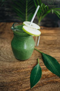 Ahşap arka planda kavanozda sağlıklı yeşil elma püresi