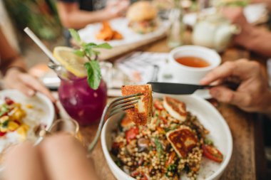 Ahşap masadaki kafede yemek yiyen arkadaşlar. yan görünüm