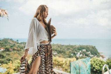 Sarışın kadın ağın tepesinde duruyor.