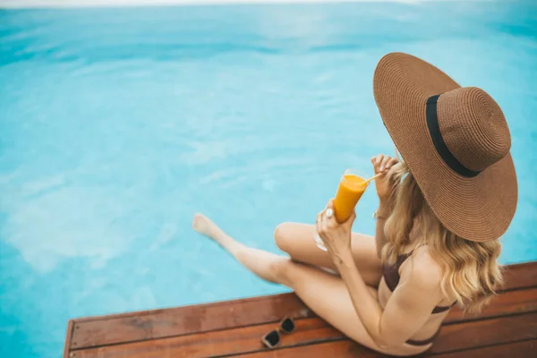 Χαμογελαστή Ξανθιά Καλοκαιρινό Καπέλο Που Κάθεται Στην Πισίνα Και Πίνει — Φωτογραφία Αρχείου