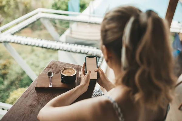 Ξανθιά Γυναίκα Πίνει Καφέ Ένα Καφέ Χρησιμοποιώντας Smartphone — Φωτογραφία Αρχείου