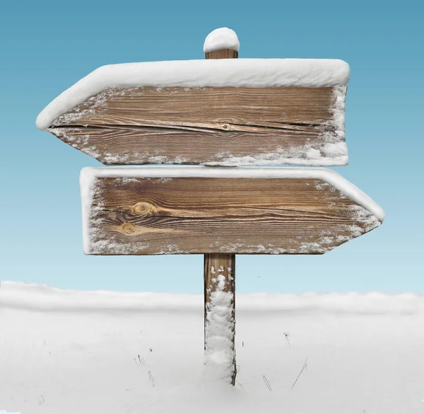 Wooden direction sign with snow and sky bg. two_arrows-opposite_