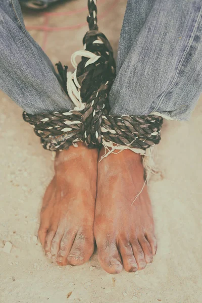 hopeless man feet tied together with rope
