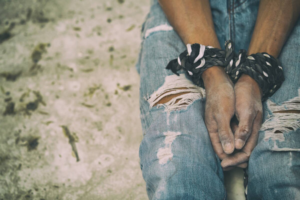 hopeless man hands tied together with rope