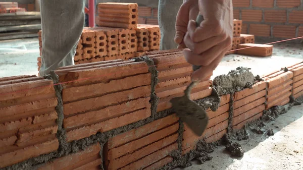 Bricklayer worker installing brick masonry on exterior wall — Stock Photo, Image