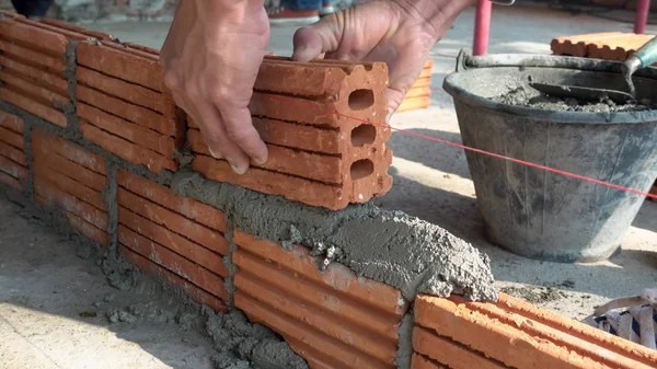 Trabalhador pedreiro instalação de alvenaria tijolo na parede exterior — Fotografia de Stock