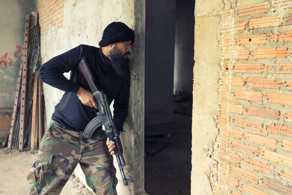 Terrorista en uniforme negro y máscara con kalashnikov — Foto de Stock