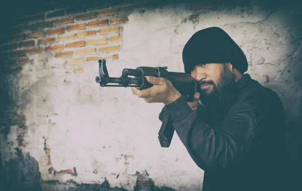 Terrorist in schwarzer Uniform und Maske mit Kalaschnikow — Stockfoto