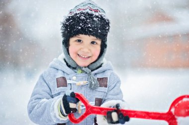Çocuk bir kürek ile karda.
