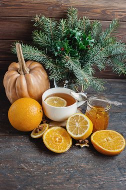 Ahşap arka plan üzerinde turuncu kabak ve zencefil reçeli ile sıcak limonlu çay fincan. Sağlıklı içecek soğuk. Kış içki