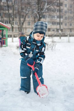 Çocuk bir kürek ile karda