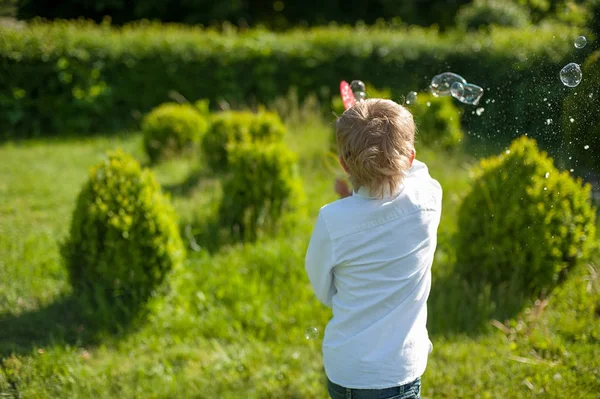 Schattig Kind Jongen Blazen Van Zeepbellen Buiten Bij Zonsondergang — Stockfoto