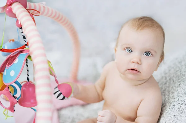 Bébé couché sur tapis en développement. jouer dans Mobile. jouets éducatifs. Doux enfant rampant et jouant avec des jouets sur le tapis — Photo