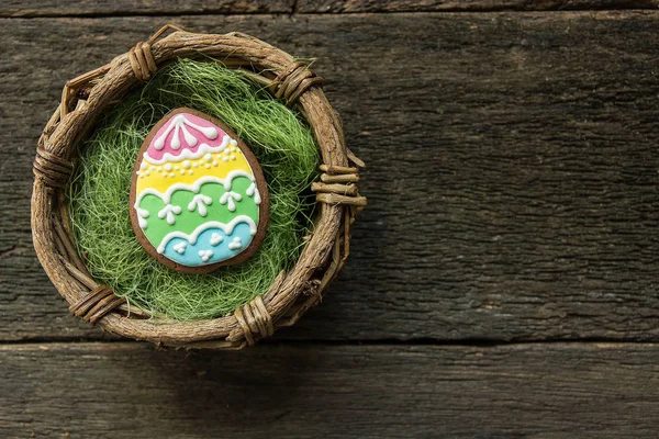 Lebkuchen in Form von bunten Eiern auf dunklem Holzgrund. — Stockfoto