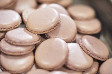 macaroons kabukları içinde bir tepsi fırından taze. Macaron acıbadem kurabiyesi, çanta pişirme hamur formu sıkma tatlı, Fransız yapma işlemi. Gıda Sanayi, birim veya kitle üretimi.