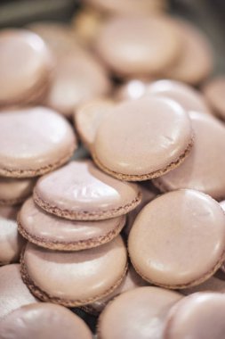macaroons kabukları içinde bir tepsi fırından taze. Macaron acıbadem kurabiyesi, çanta pişirme hamur formu sıkma tatlı, Fransız yapma işlemi. Gıda Sanayi, birim veya kitle üretimi.