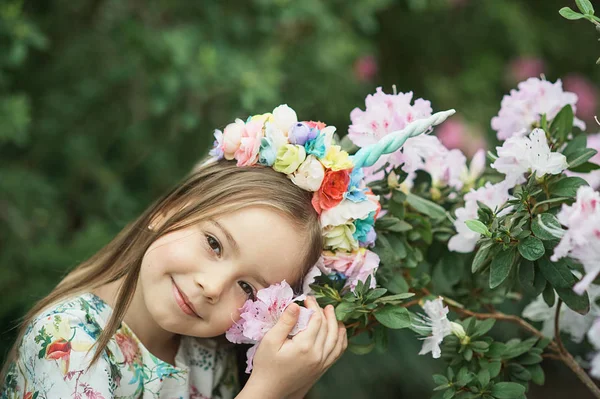 Fantasy little girl with rainbow unicorn horn with flowers in azalea park. for Halloween — Stock Photo, Image