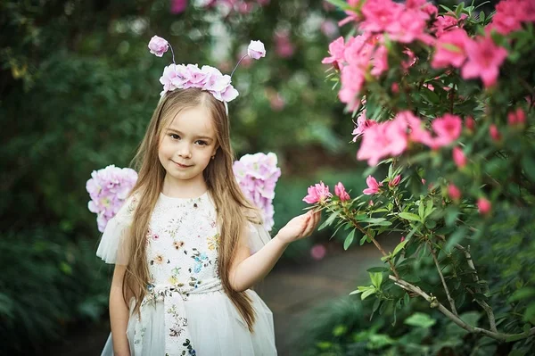 ツツジの花を嗅ぐ少女。公園内のツツジの開花 — ストック写真