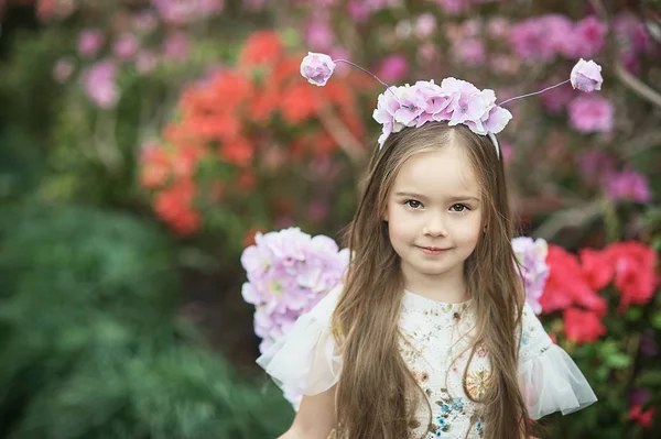 Girl sniffing flowers of azaleas. flowering azaleas in the park — Stock Photo, Image