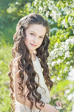 Esmer kız çiçek açan elma bahçesinde bahar yürüyüş