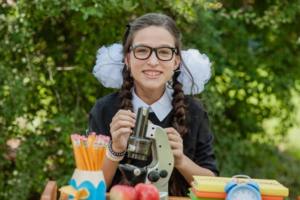 Porträtt av en vacker ung Skolflicka sitter vid ett skrivbord — Stockfoto